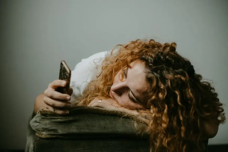 Mujer viendo su celular una de lo factores que hace que utilicemos las técnicas de relajación para dormir