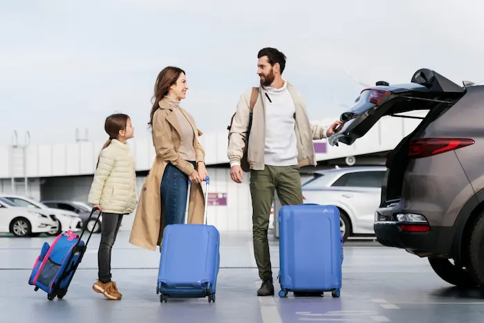 familia con sus maletas, apunto de ir de paseo en auto