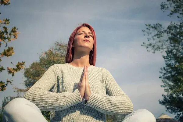 mujer respirando en medio del bosque